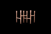 Two copper candle holders shown interlocked together on a solid black background.