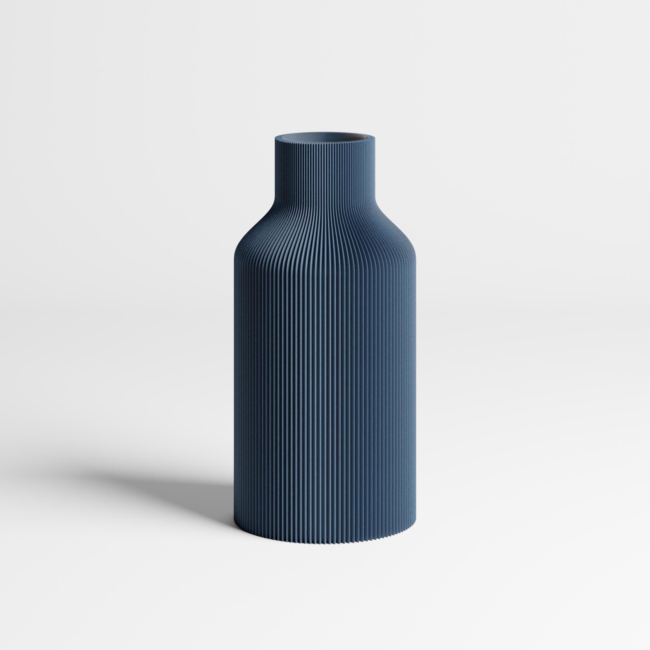 An navy blue ribbed vase with a flared neck, standing on a light gray surface against a white background.