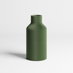 An olive green ribbed vase with a flared neck, standing on a light gray surface against a white background.