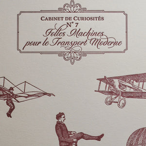 A close up of vintage-style illustrated art print with French text in an ornate frame, featuring burgundy drawings of an airplane, a winged figure, and a seated man on an old bicycle on off-white cotton paper.