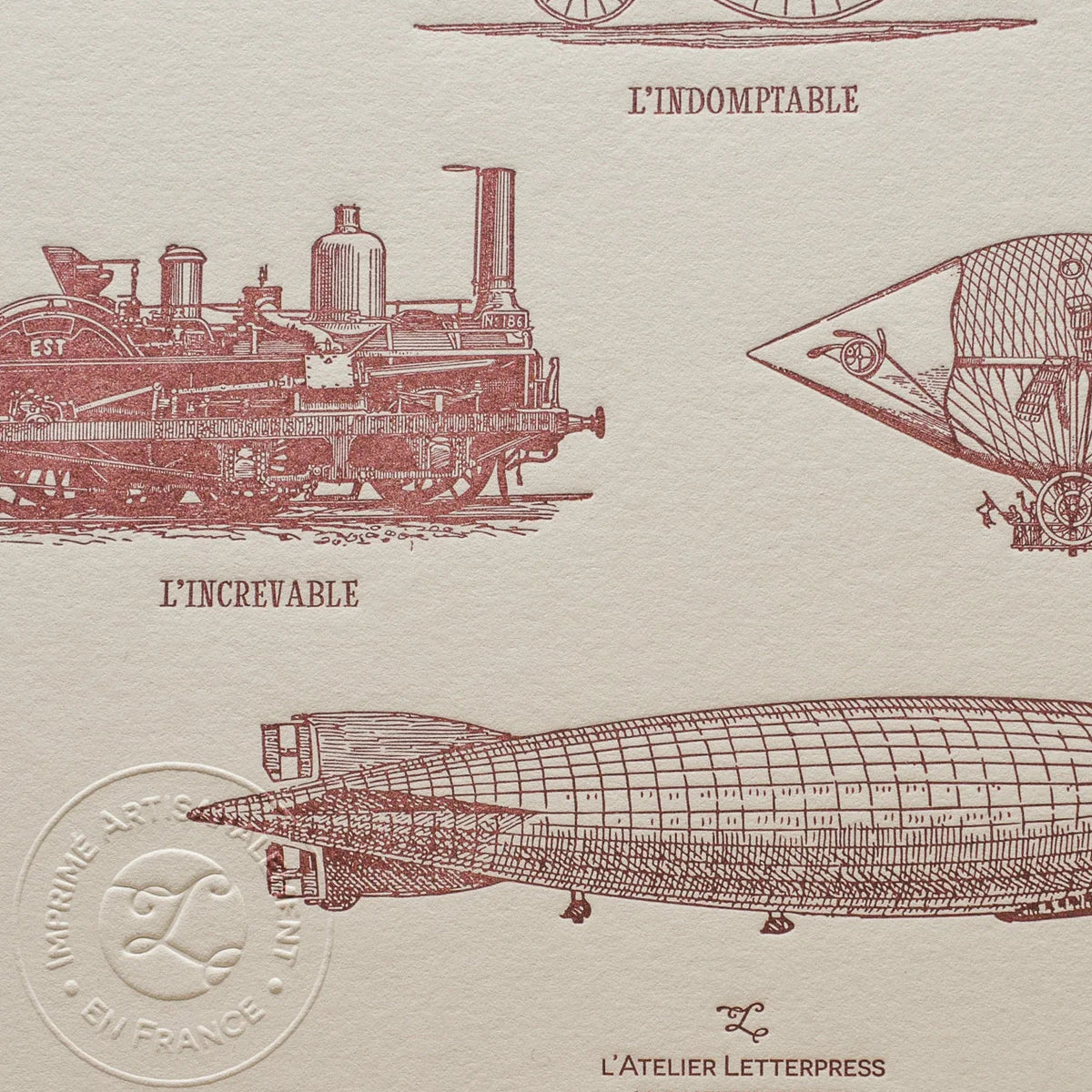 A close up of vintage-style illustrated art print with illustrations of a steam locomotive and a zeppelin on off-white cotton paper, showing the embossed stamp of authenticity.