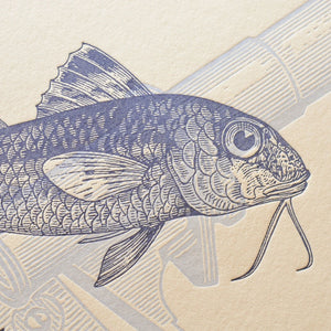 A close up of vintage-style illustrated art print featuring a blue detailed drawing of a fish on textured off-white cotton paper.