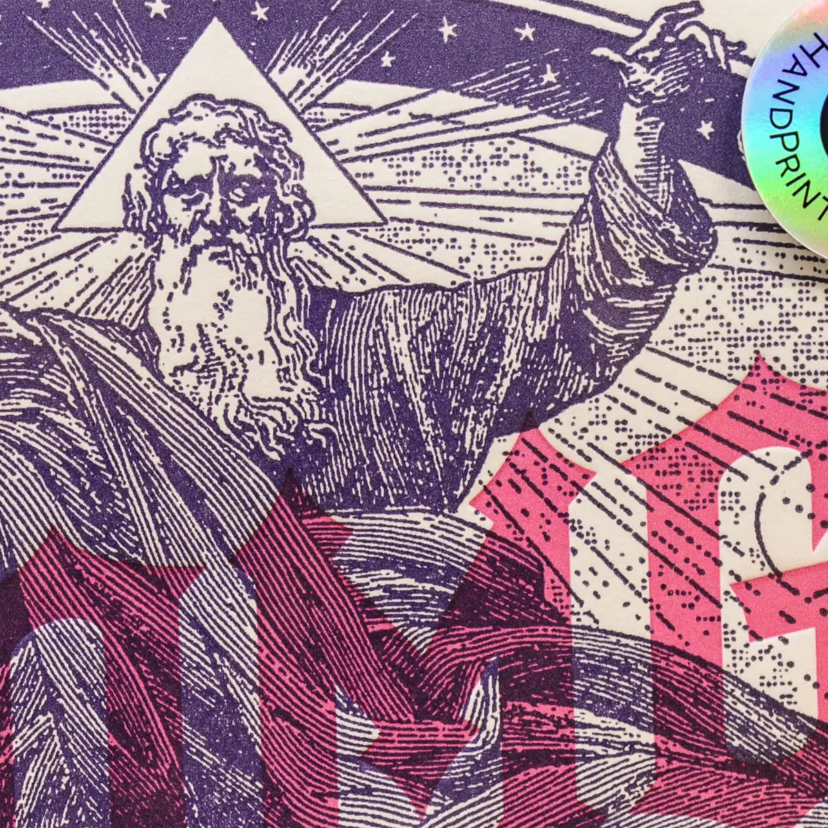 A close-up of a printed graphic featuring an illustrated bearded figure in a purple linocut-style design, with a cream background. A circular iridescent sticker reading 'HAND PRINT' appears in the top right corner.