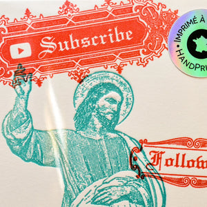 A close-up of a printed art card featuring a teal illustration of a religious figure raising his hand, with red decorative text reading 'Subscribe' and 'Follow Me' plus a circular holographic sticker on the outside protective sleeve.