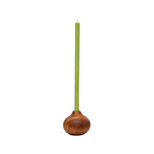 A tall, slender light green thin candle set in a rounded, medium, hand-carved wooden candle holder with a warm brown finish, on a white background.