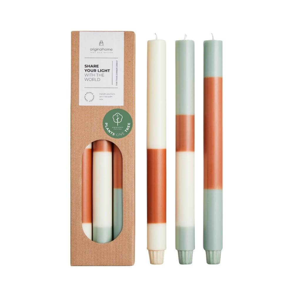 Three pastel coloured candles with horizontal bands of cream, sage green, and terracotta, shown next to their kraft paper packaging box on a white background.