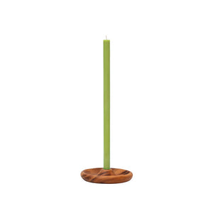 A tall, slim light green candle standing upright in a round wooden candle holder with a natural brown wood grain finish, set against a plain white background.
