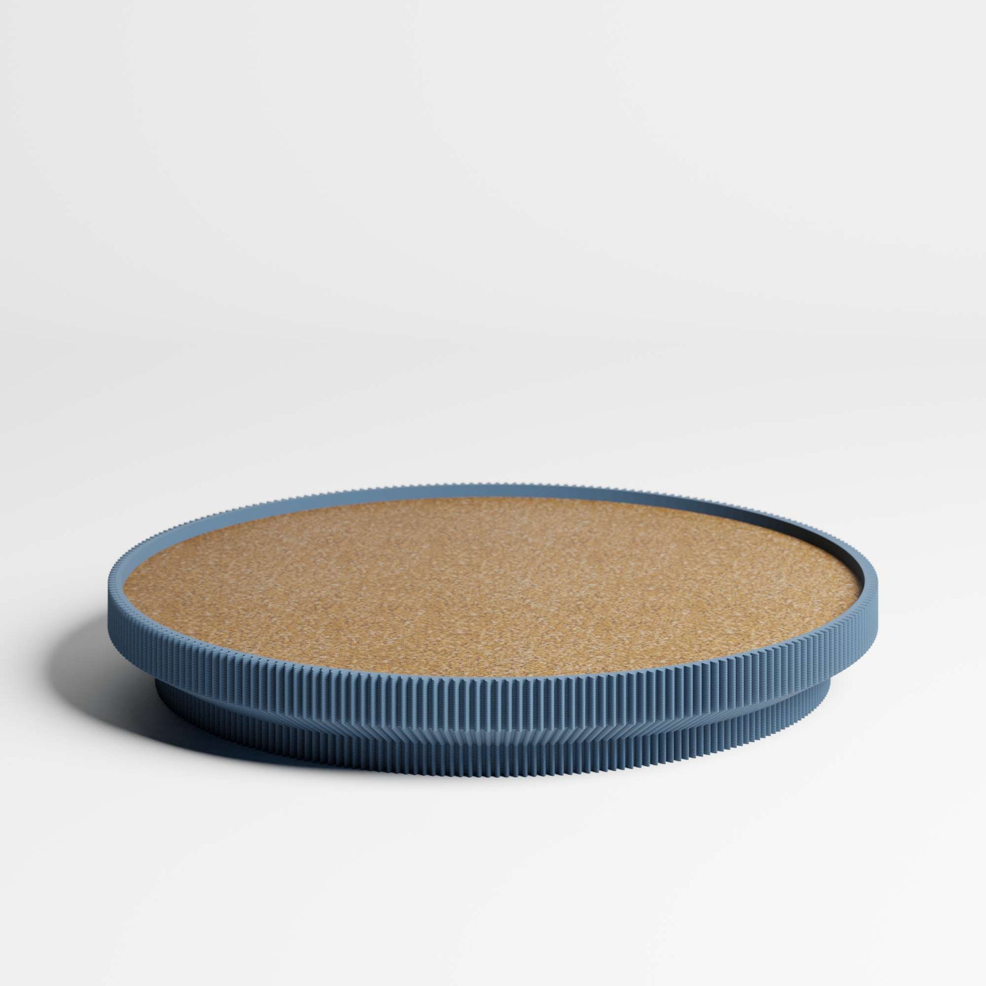 A round tray with a cork top and a navy blue ribbed rim, photographed on a clean white studio background.