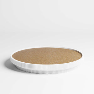 A round tray with a cork top and a white ribbed rim, photographed on a clean white studio background.