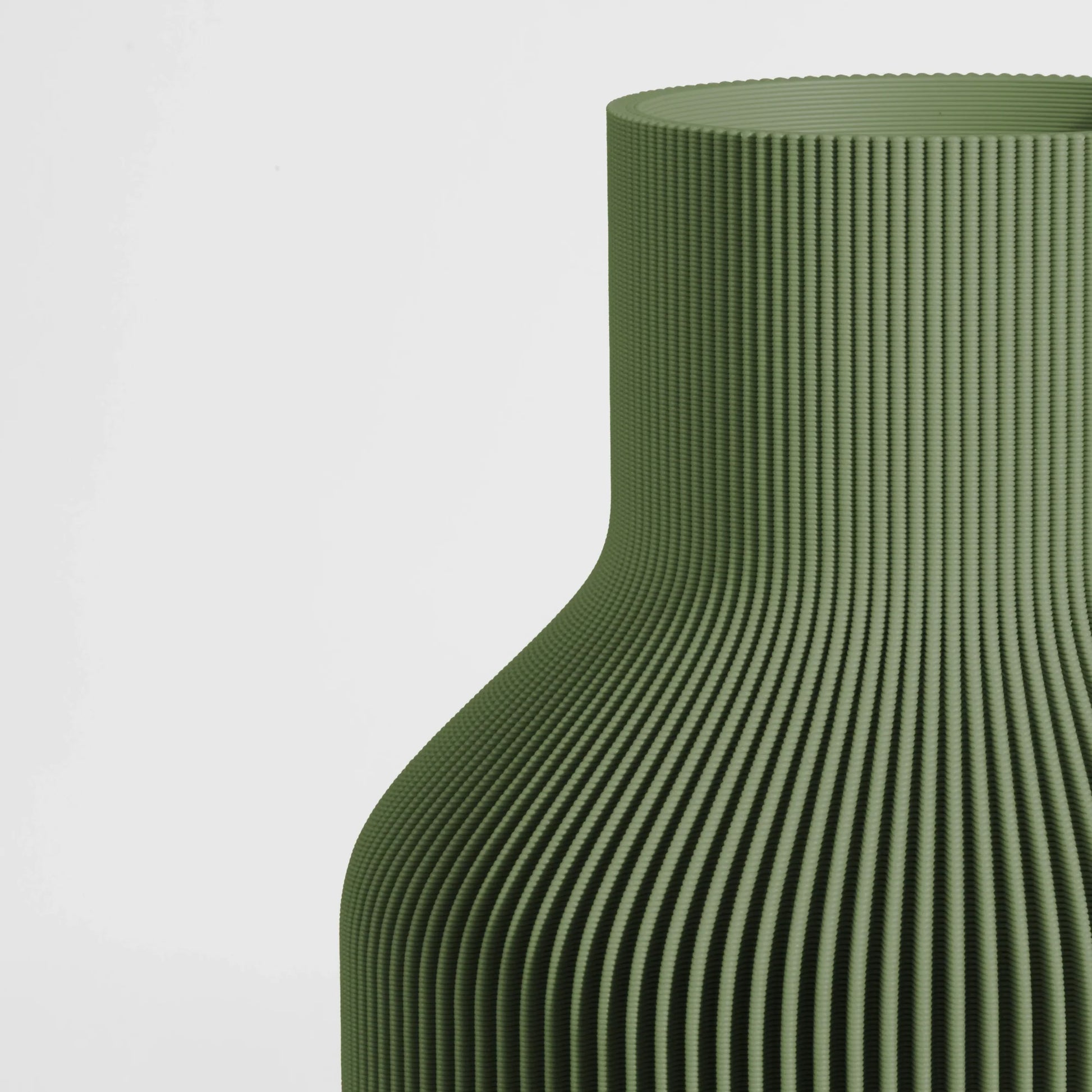 Close-up of a textured dark green vase on a light gray background