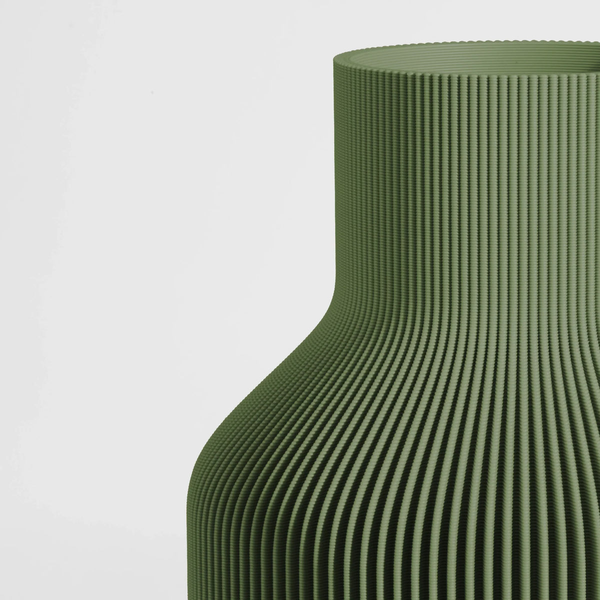 Close-up of a textured dark green vase on a light gray background