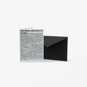 A minimalist black envelope standing next to a white greeting card printed with the text 'INSPIRING ARCHITECT'S WORDS' and dense small text below, on a clean white background.