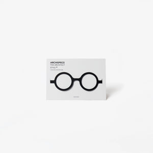 A minimalist architectural card featuring a white card with black cut out cardboard circular eyeglass, shown on a light gray background.