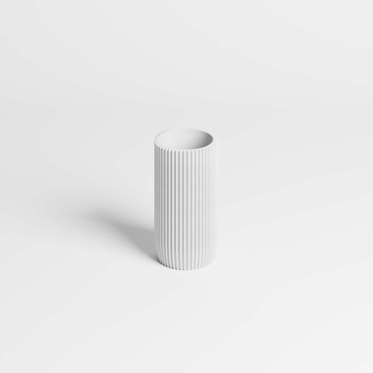 A minimalist white pen holder with vertical fluted ridges, standing on a clean white background with a soft shadow.
