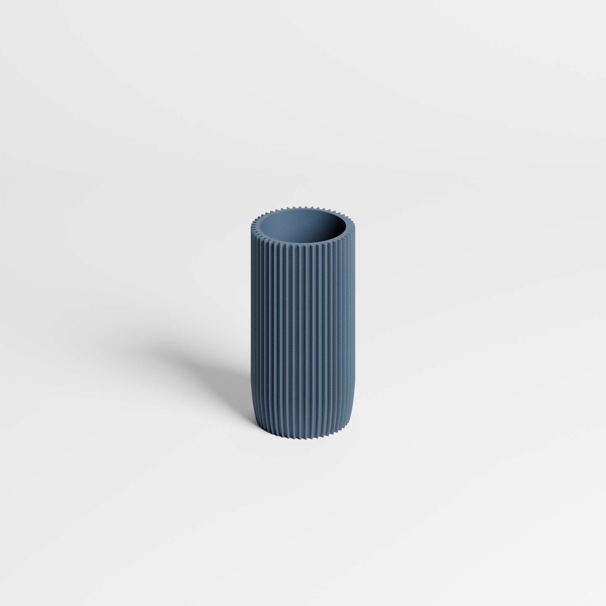 A modern, ribbed cylindrical vase in a muted slate blue color, standing upright on a clean white background.
