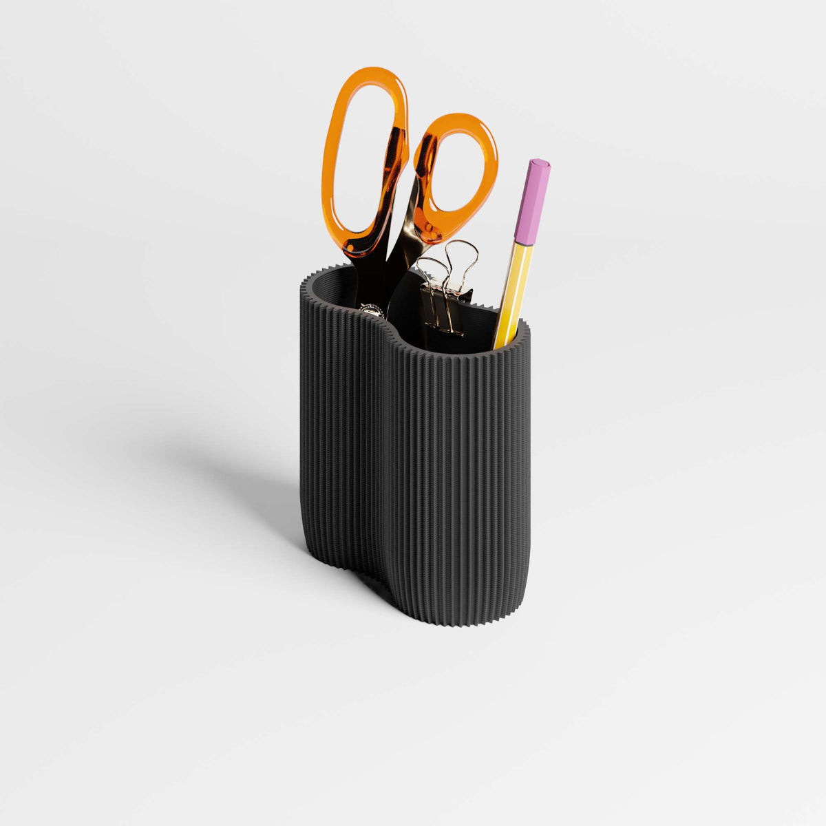 Black ribbed pen holder with office supplies on a light gray background
