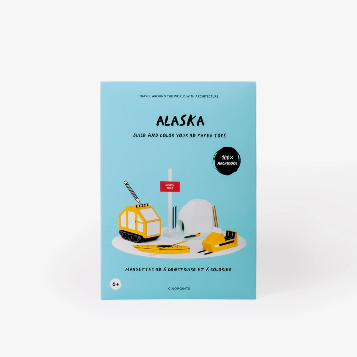 Alaska paper model kit folder featuring a light blue cover standing upright against a clean white background. The cover shows a stylised illustration of a paper model igloo, snowmobile and other winter items with paintbrushes and pencil.
