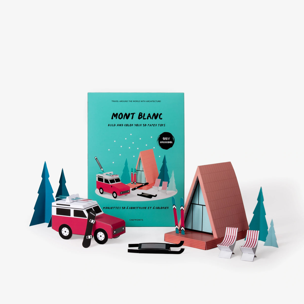Mont Blanc paper model kit folder displayed on a white background, and in front a red and white camper van, a wooden A-frame cabin, chairs, trees, and other winter-themed accessories, all coloured in.